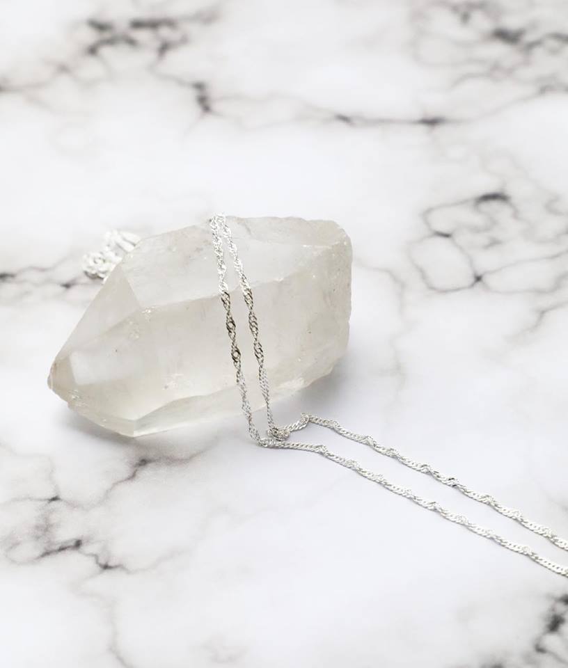 Sterling silver Singapore Italian chain laying over a quartz stone.