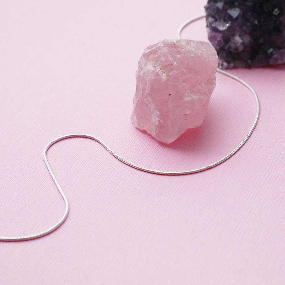 1MM Sterling Silver Snake Chain with Lobster Claw Clasp. Italian Sterling Silver, 16"-30". Placed next to a rose quartz crystal.
