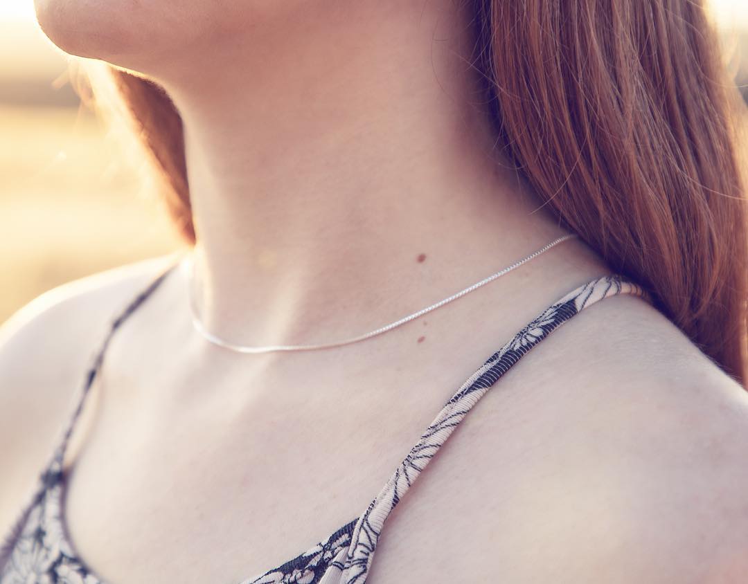 16" .8 sterling silver 925 box chain on a young woman's neck.
