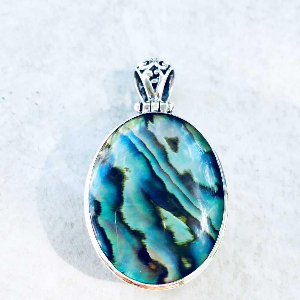Abalone or Red Coral double sided Sterling Silver Pendant. Abalone on one side, red coral on the other. Oval shape. one and a half inches lon