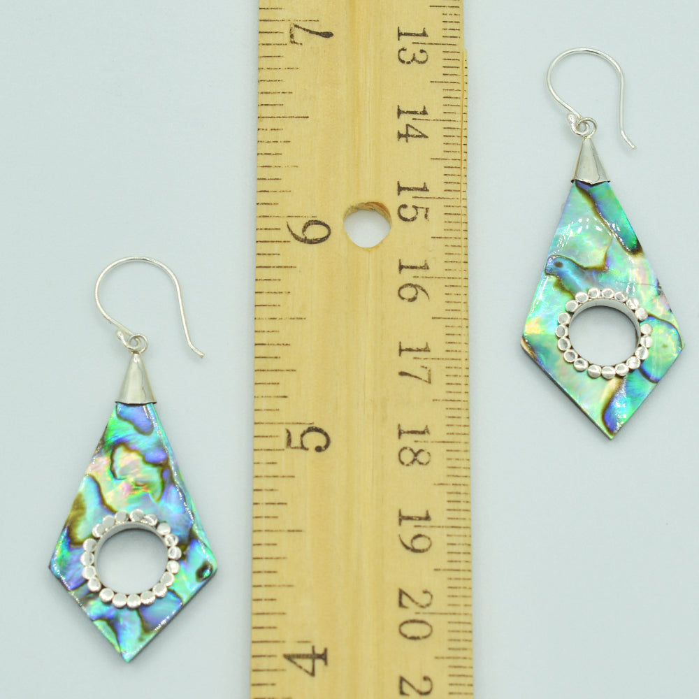 Abalone or Mother of Pearl Sterling Silver Earrings. Geometric diamond shape. Silver work. one and a quarter inch long. Pierced earrings. Fish hook There is a whole cut out in the center with silver scalloped around the edge of the whole.