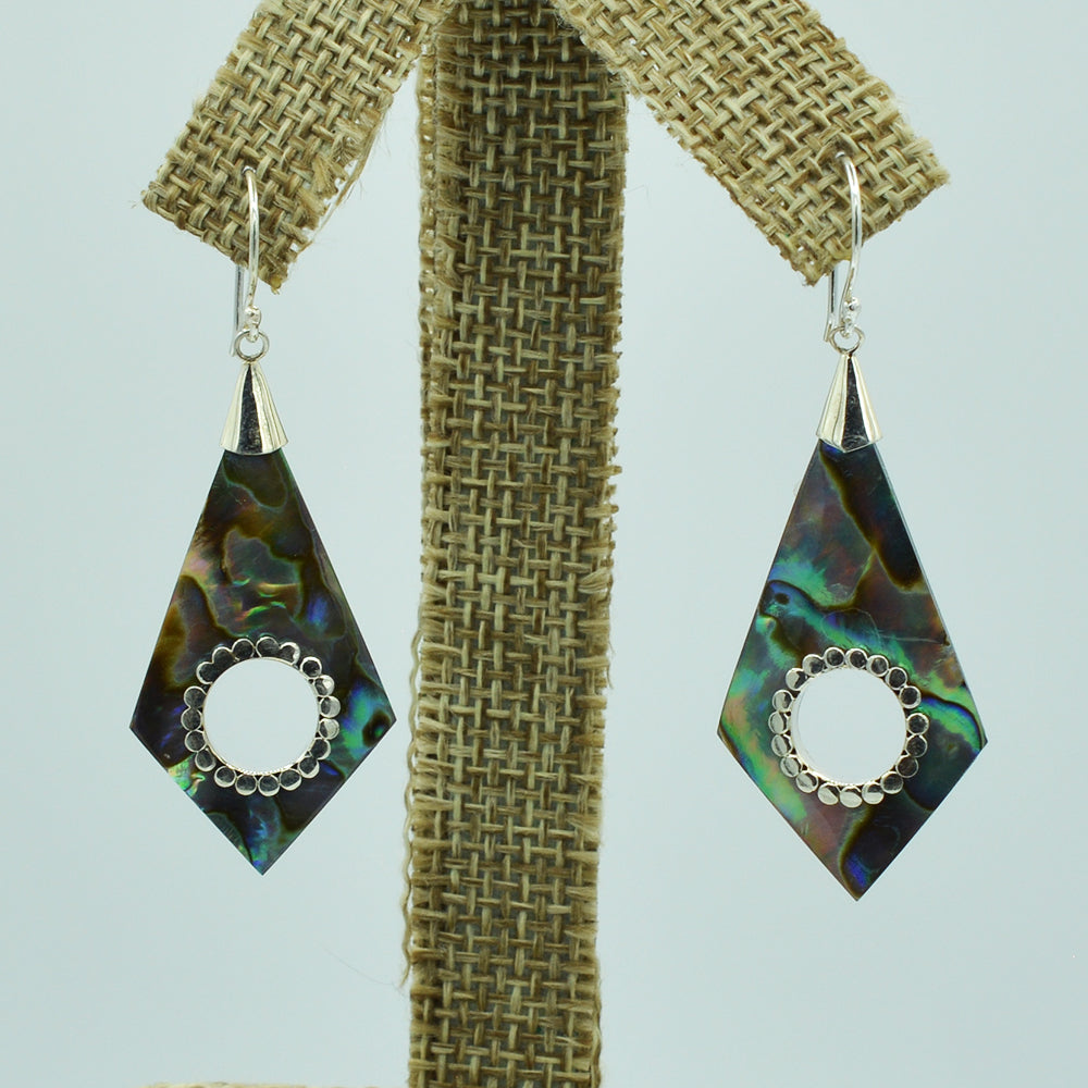 Abalone or Mother of Pearl Sterling Silver Earrings. Geometric diamond shape. Silver work. one and a quarter inch long. Pierced earrings. Fish hook There is a whole cut out in the center with silver scalloped around the edge of the whole.