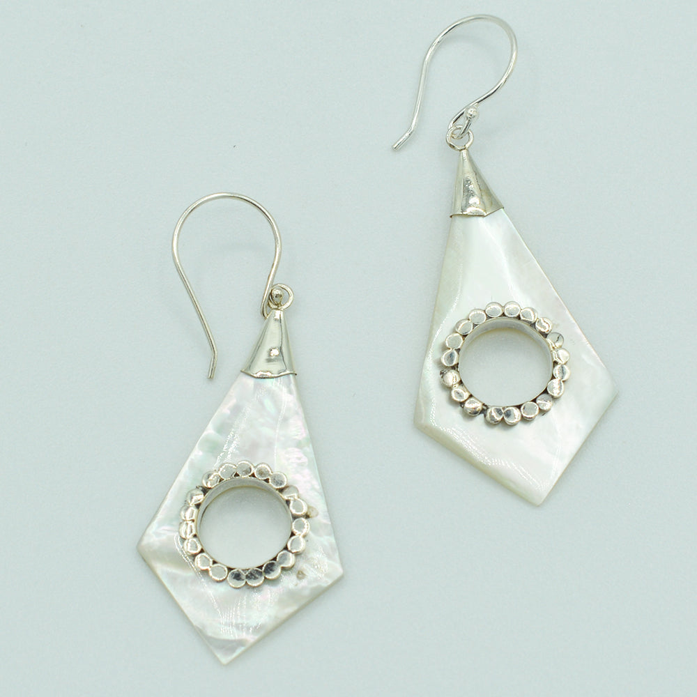 Abalone or Mother of Pearl Sterling Silver Earrings. Geometric diamond shape. Silver work. one and a quarter inch long. Pierced earrings. Fish hook There is a whole cut out in the center with silver scalloped around the edge of the whole.