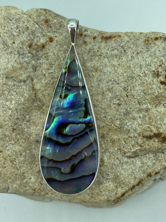 Double sided sterling silver pendant. Abalone on one side and Red Coral on the other. The shape is tear drop. this is a longer pendant. Nearly 2 inches. Very dramatic.