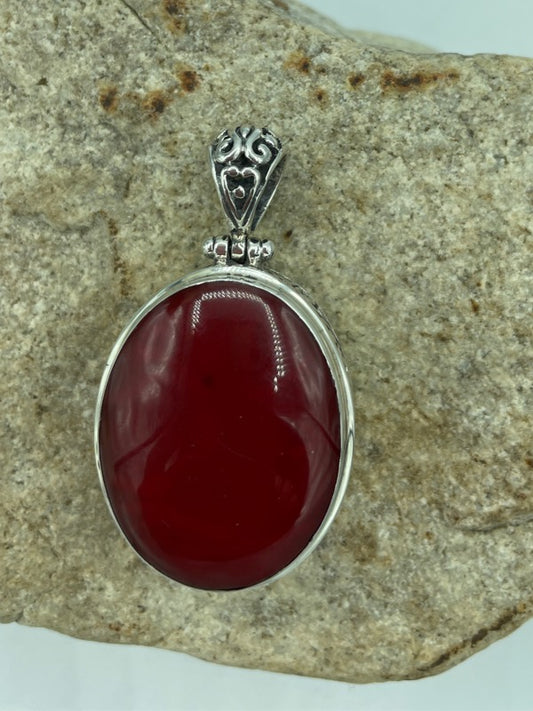 Double sided sterling silver oval shape pendant.  Abalone on one side and red coral on the other. The pendant is closer to 1.5'' long. a bold lovely piece.
