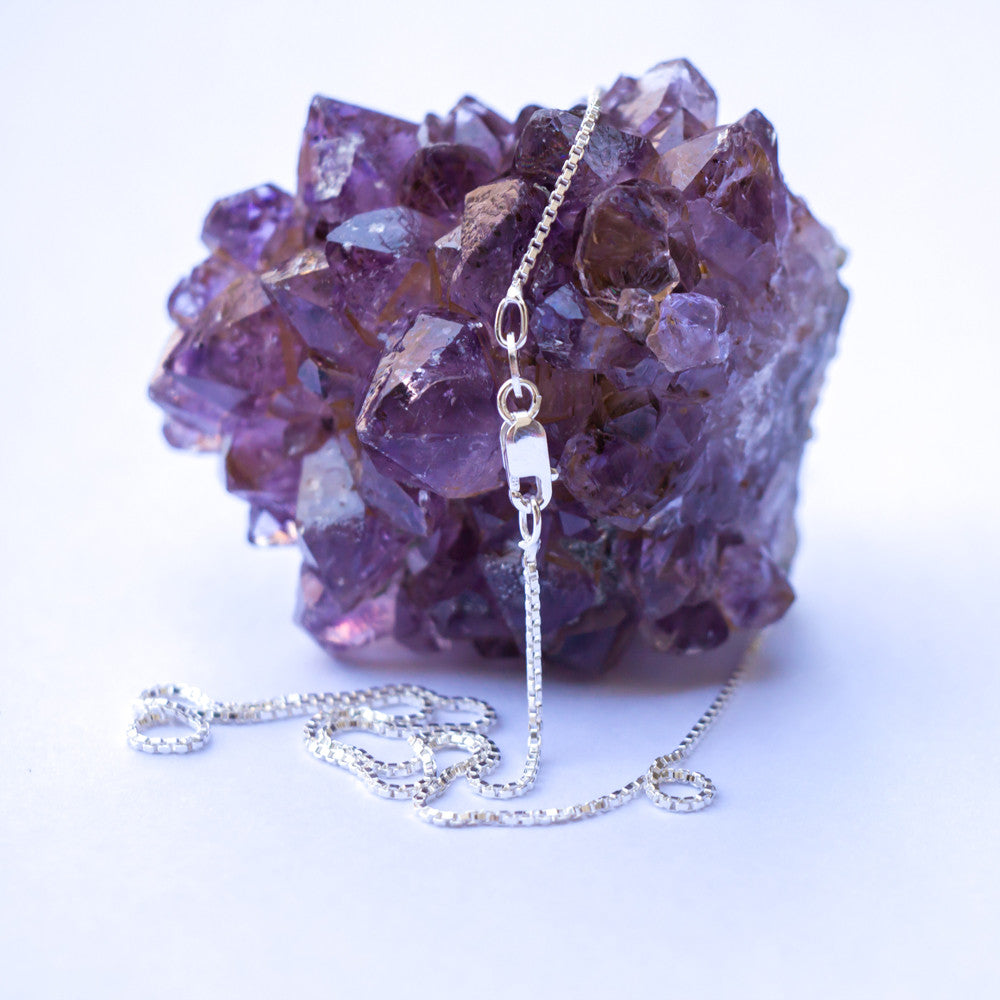 .8MM Sterling Silver Box Chain with Lobster Claw Clasp. Perfect for pendants. Pictured on an amethysts geode stone.