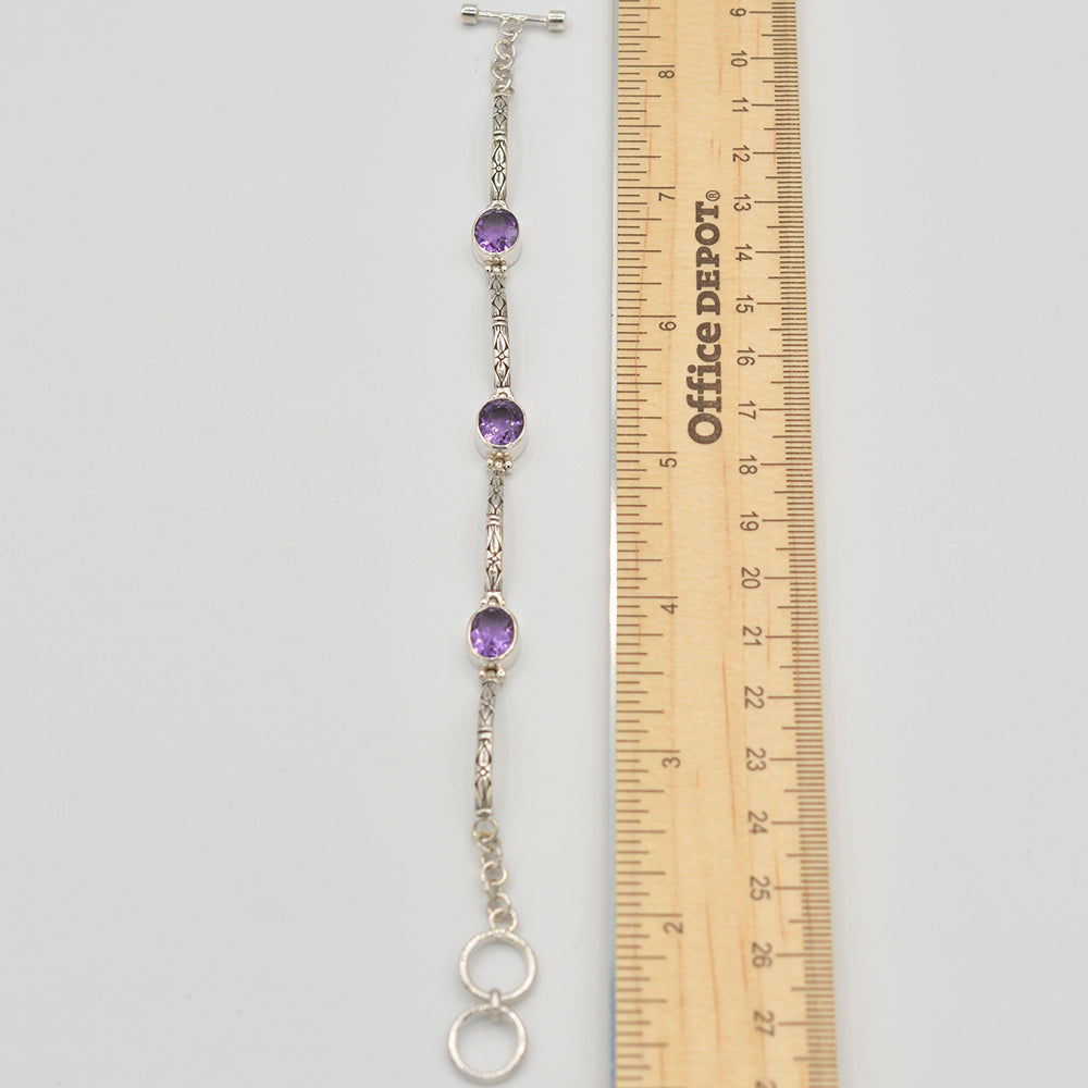 Oval shape amethysts semi-precious stone toggle bracelet. 3 stones, separated by designed bars of sterling. Adjustable from 7"-8"