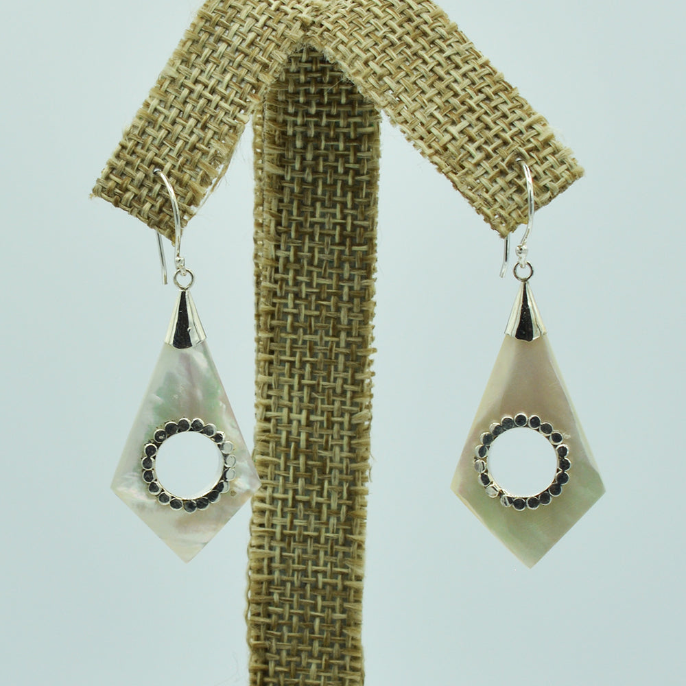 Abalone or Mother of Pearl Sterling Silver Earrings. Geometric diamond shape. Silver work. one and a quarter inch long. Pierced earrings. Fish hook There is a whole cut out in the center with silver scalloped around the edge of the whole.